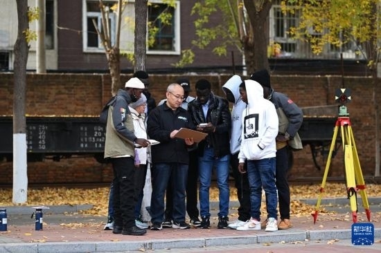 在天津鐵道職業(yè)技術學院，老師指導幾內(nèi)亞學員使用測距儀器（11月11日攝）。新華社記者 李然 攝