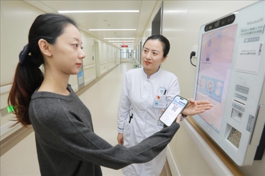 醫(yī)護(hù)人員引導(dǎo)患者在自助機(jī)前辦理自助入院手續(xù)。圖片來(lái)源：山東第一醫(yī)科大學(xué)第二附屬醫(yī)院