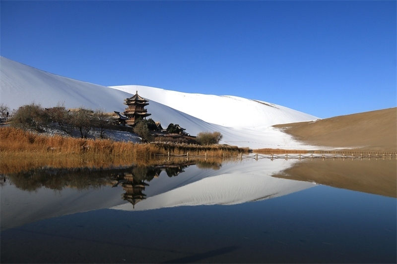 鳴沙山月牙泉景區(qū)雪景。敦煌市委宣傳部供圖，張曉亮攝