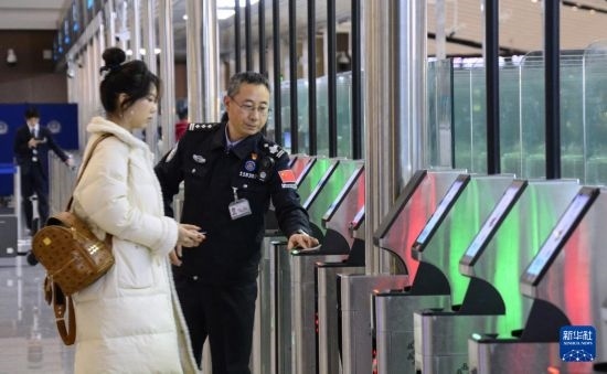1月2日，大興機(jī)場(chǎng)邊檢站警察指導(dǎo)旅客使用自助出境設(shè)備。新華社記者 李欣 攝