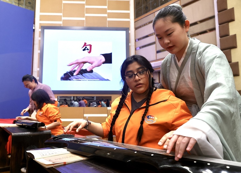 2024年3月20日，美國華盛頓州中學(xué)生代表團(tuán)北京大學(xué)交流活動在北京大學(xué)英杰交流中心舉行。圖為來自華盛頓州的中學(xué)生體驗古琴。