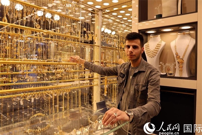 一名銷售員展示黃金飾品。人民網(wǎng) 伊納斯·易卜拉欣攝