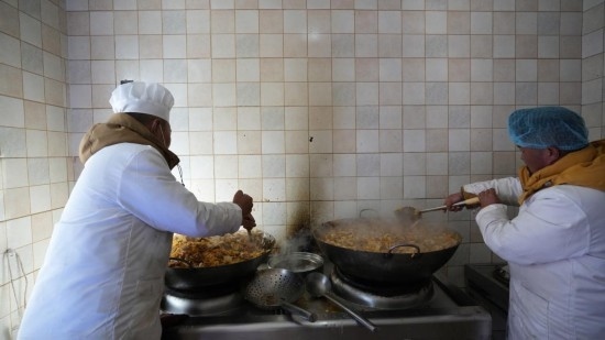 1月14日，服務(wù)隊(duì)的兩名廚師正在為村民們做午飯。新華社記者 邱星翔 攝