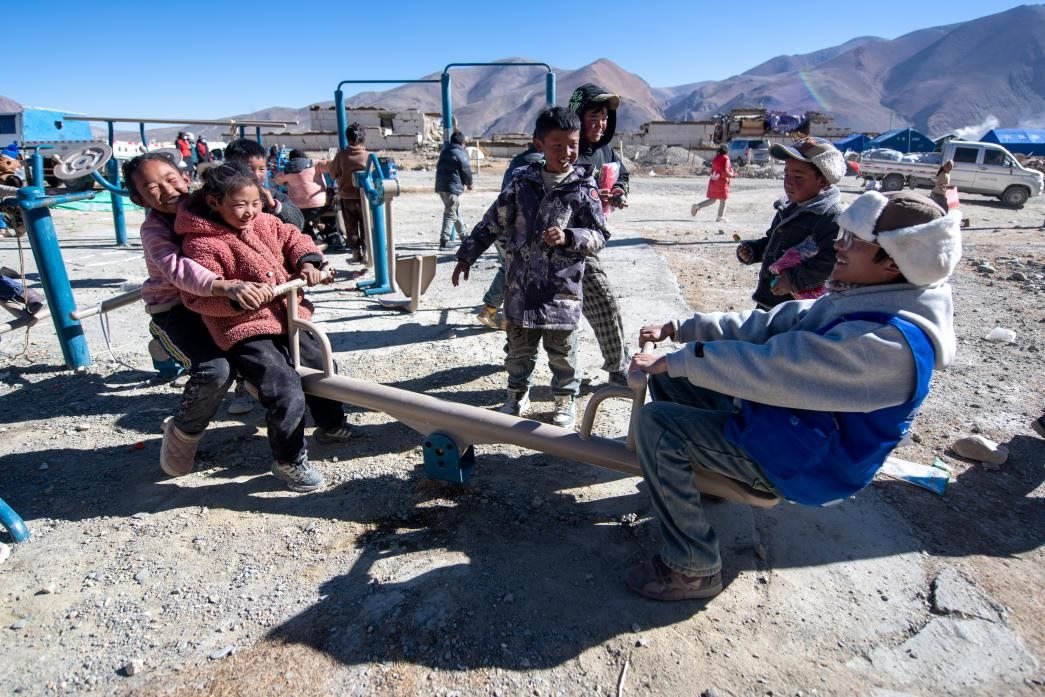 1月11日，在定日縣措果鄉(xiāng)塘仁村安置點(diǎn)，西藏星光社會(huì)工作服務(wù)中心志愿者和孩子們一起玩耍，進(jìn)行災(zāi)后心理疏導(dǎo)。人民網(wǎng)記者 翁奇羽攝