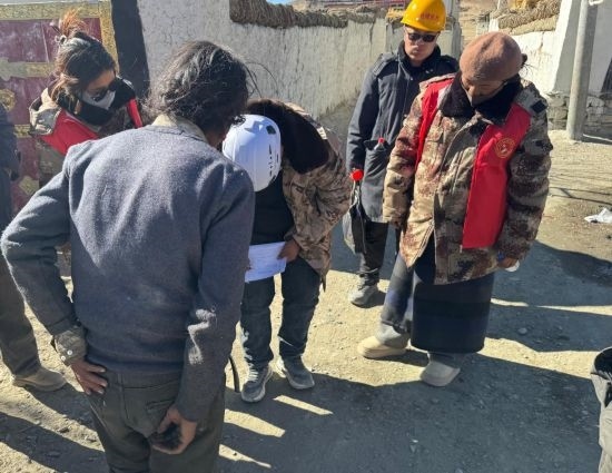 1月13日，次旺（右一）陪同工作組走訪村莊，評估房屋受損程度。新華社發(fā)