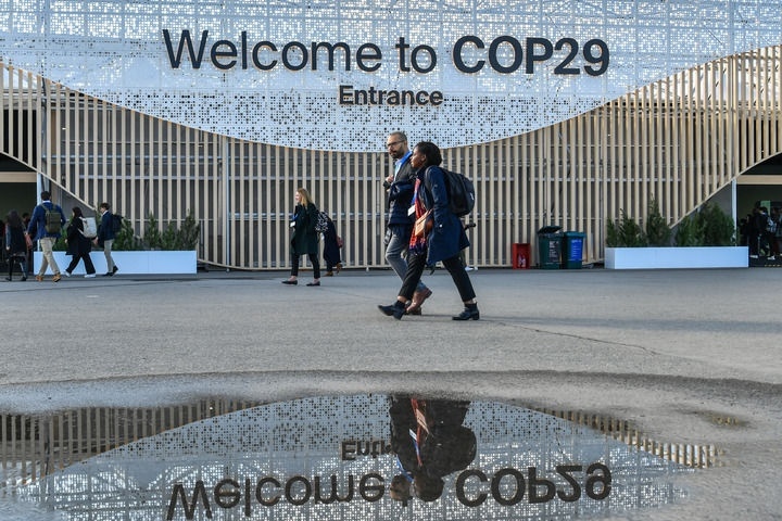 2024年11月15日，在阿塞拜疆首都巴庫，人們經(jīng)過聯(lián)合國氣候變化巴庫大會(huì)的會(huì)場。新華社記者 曹陽 攝