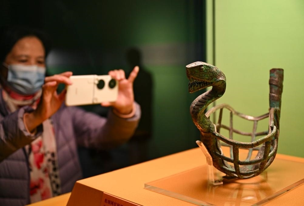 1月14日，觀眾在上海博物館蛇年迎春展拍攝展品蛇綱網(wǎng)狀銅器。新華社發(fā)（陳浩明攝）
