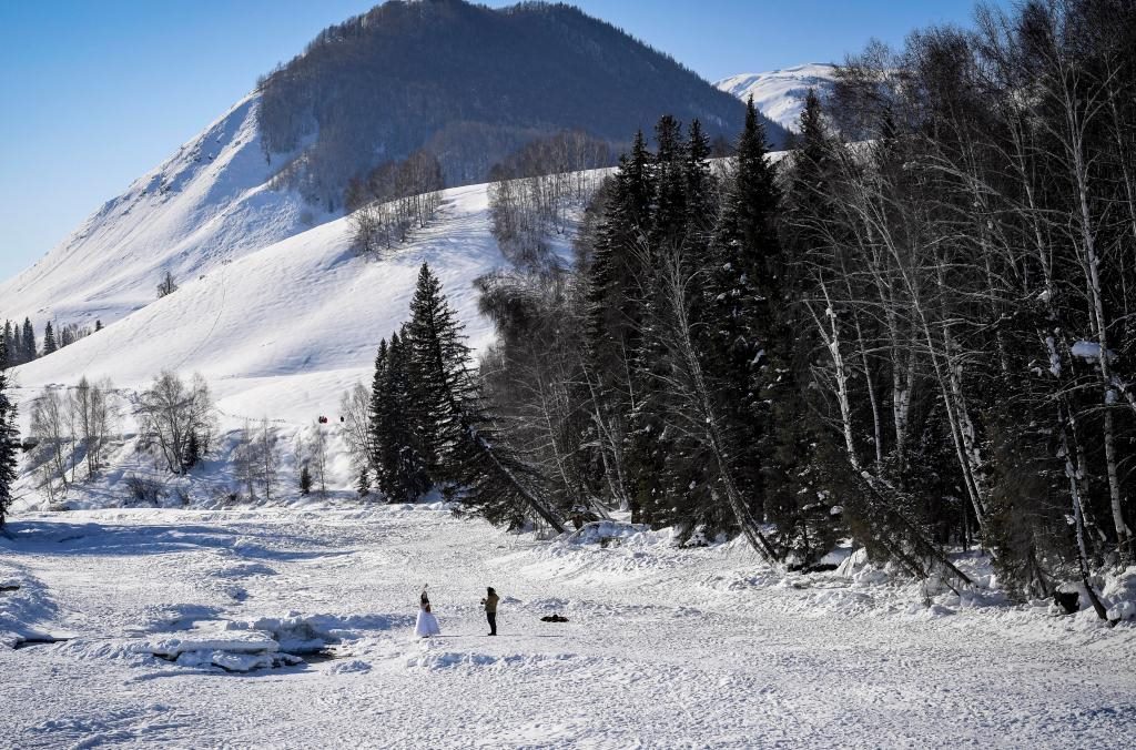 2024年2月5日，兩名游客在新疆阿勒泰地區(qū)布爾津縣禾木村拍照。新華社記者 馬鍇 攝