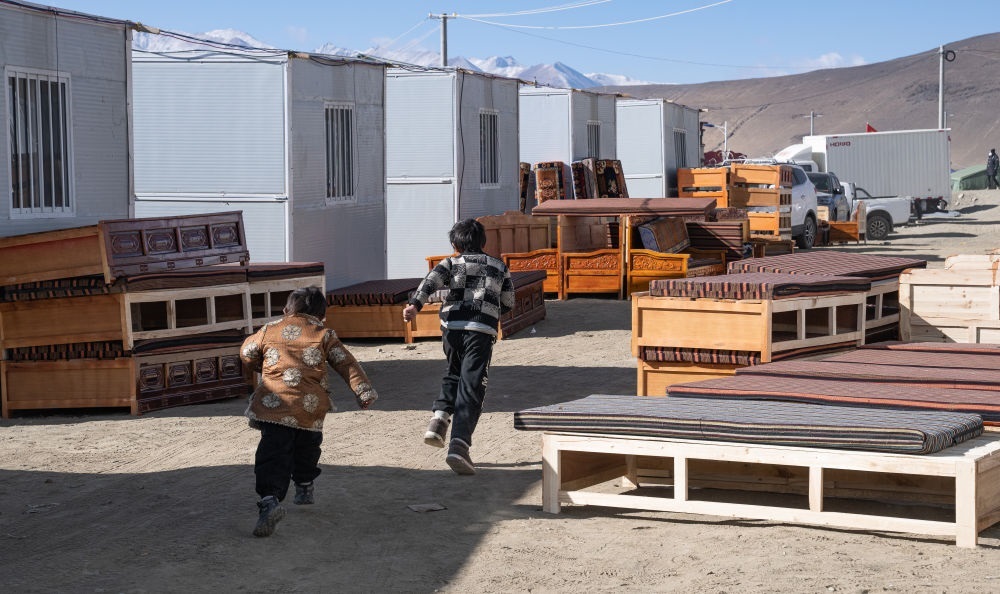 2025年1月13日，在定日縣嘎旦村，兩個孩子在剛運來的兩排藏床間奔跑。新華社記者丁增尼達 攝