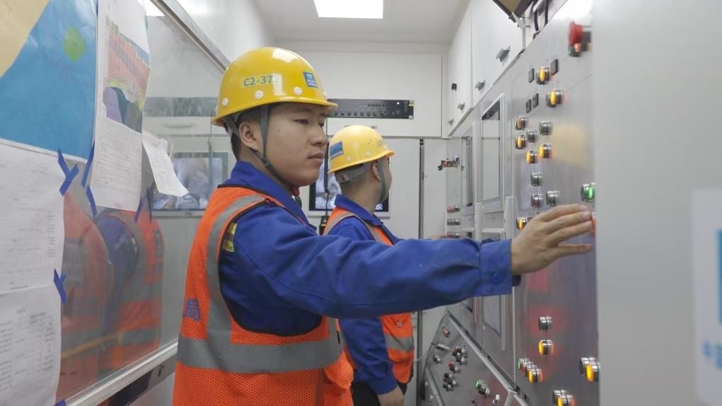 盾構(gòu)司機(jī)何曉波在駕駛室內(nèi)調(diào)試盾構(gòu)機(jī)參數(shù)。（劉芬攝）