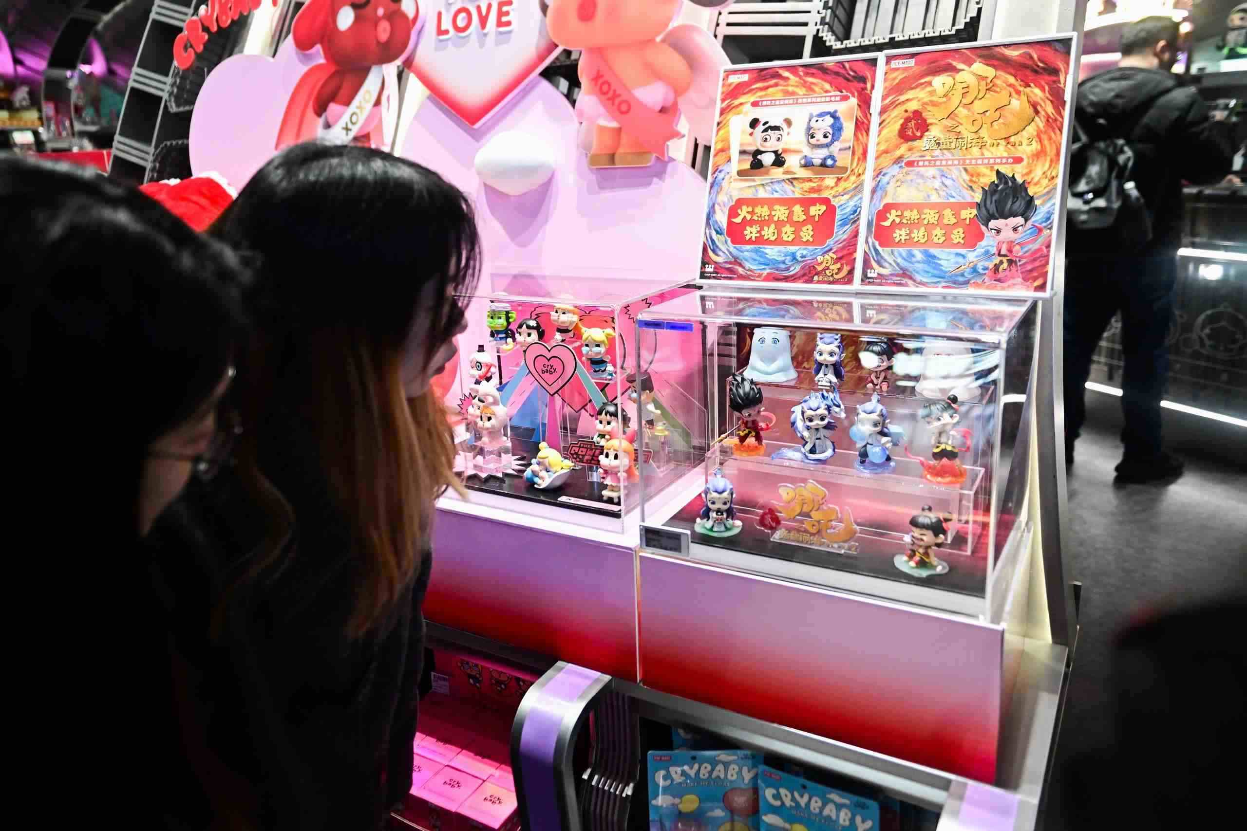 △2025年2月22日，上海，市民在圍觀《哪吒之魔童鬧?！废嚓P(guān)手辦盲盒。