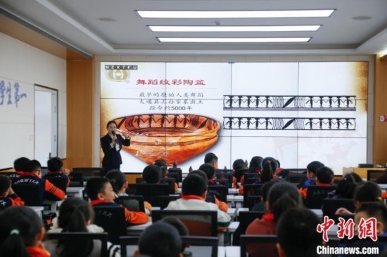 圖為學(xué)生在“國寶音樂會(huì)”社教課中了解舞蹈紋彩陶盆。中新社記者 馬銘言 攝
