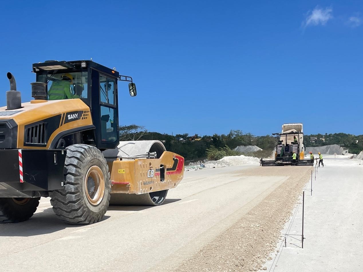 圖為中企承建的牙買加蒙特哥貝繞城路項目基層試驗段正在進行攤鋪和碾壓施工，相關施工工作已于日前順利完成。中國港灣美洲區(qū)域公司供圖
