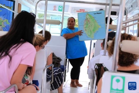 3月15日，一名導(dǎo)游在游艇上為游客介紹塞舌爾拉迪格島。新華社記者 董江輝 攝