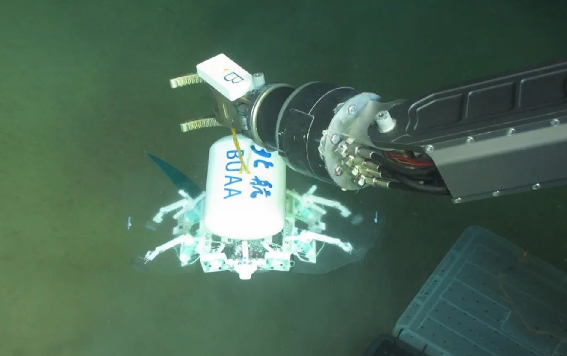 科研人員利用機(jī)械臂將北航深海小型機(jī)器人投于馬里亞納海溝。校方供圖