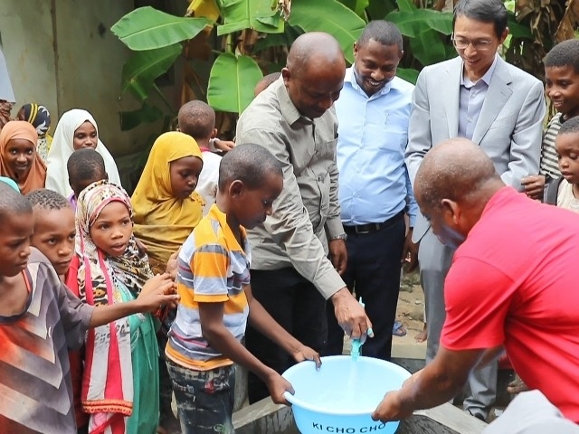 在日前舉行的安全供水工程揭牌儀式上，當(dāng)?shù)匦∨笥言诠┧c(diǎn)接水。 施亮攝