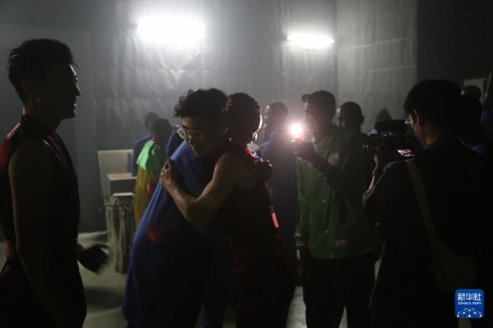 4月10日，在塞內(nèi)加爾首都達喀爾的國家大劇院，中央音樂學院進擊打擊樂團成員與塞內(nèi)加爾杜杜·恩迪亞耶·羅斯打擊樂團成員在演出后臺擁抱。新華社記者 司源 攝