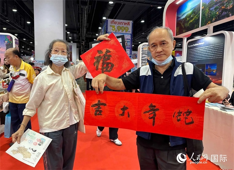 2025蛇年春節(jié)，泰國市民展示他們領(lǐng)到的華人手寫春聯(lián)。人民網(wǎng)記者 簡承淵攝