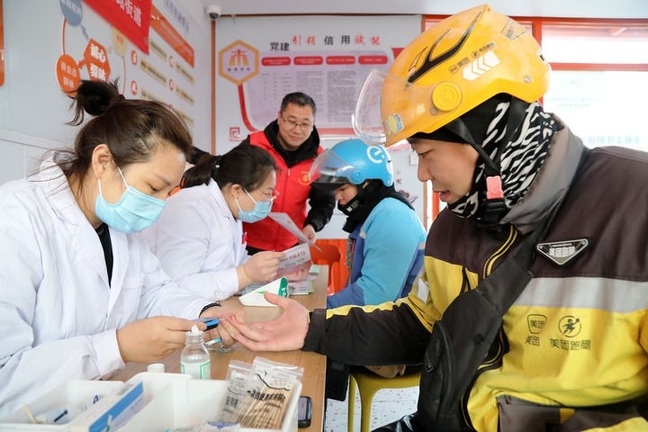 2025年3月5日，志愿者在山東省棗莊市市中區(qū)一工會驛站為外賣員免費(fèi)測量血糖。新華社發(fā)（王海楠攝）