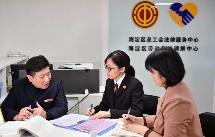 2025年3月6日，在北京市海淀區(qū)總工會勞動爭議調(diào)解中心，海淀區(qū)人民法院法官王琰（中）與該中心工作人員就糾紛化解情況進(jìn)行溝通。新華社記者 趙婷婷 攝