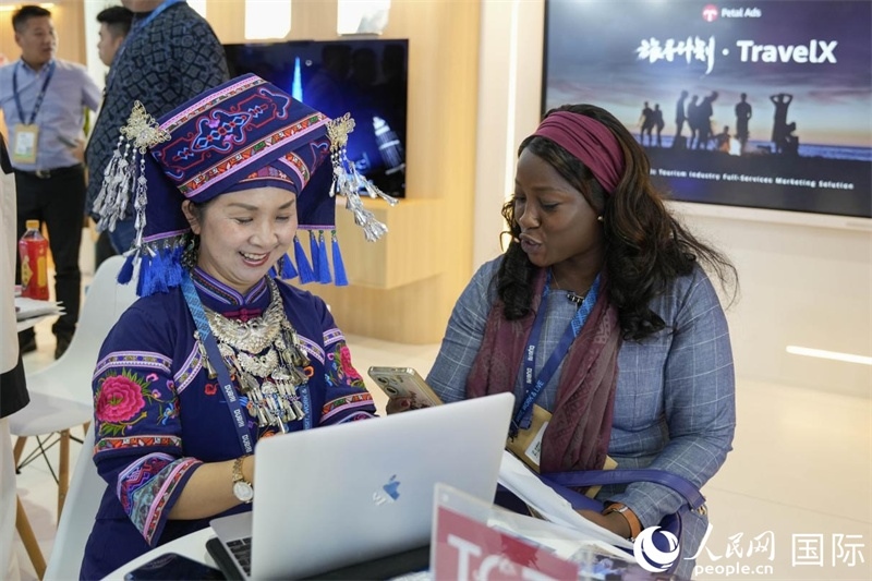 來自廣西的旅游業(yè)者同客戶交流。人民網(wǎng)塔里克·易卜拉欣攝