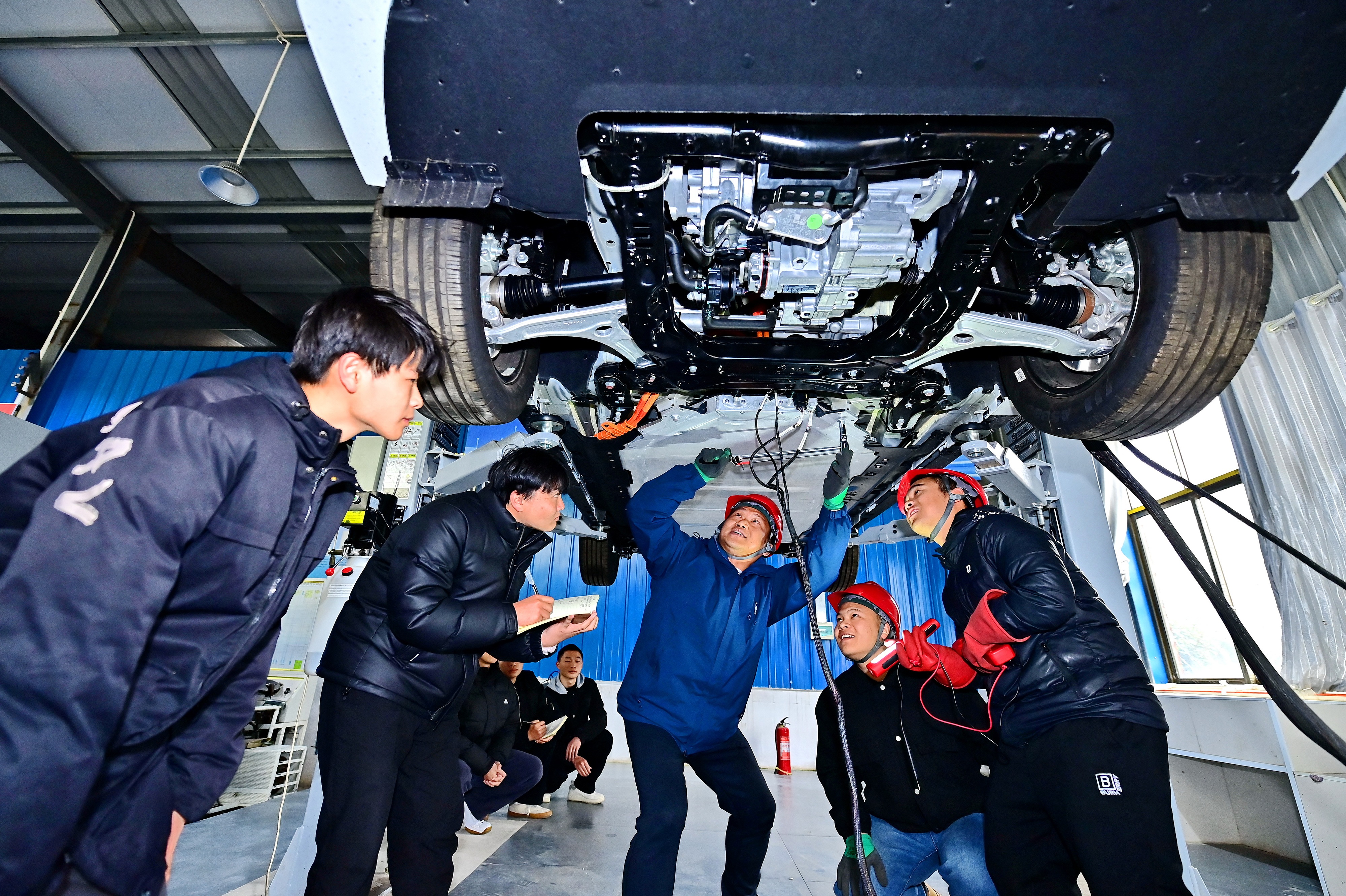 2025年2月，江西省宜春市，豐城市的一所技工學(xué)校實(shí)訓(xùn)基地內(nèi)，新能源汽車運(yùn)維專業(yè)學(xué)生在老師的指導(dǎo)下學(xué)習(xí)新能源汽車電池包檢修技術(shù)。