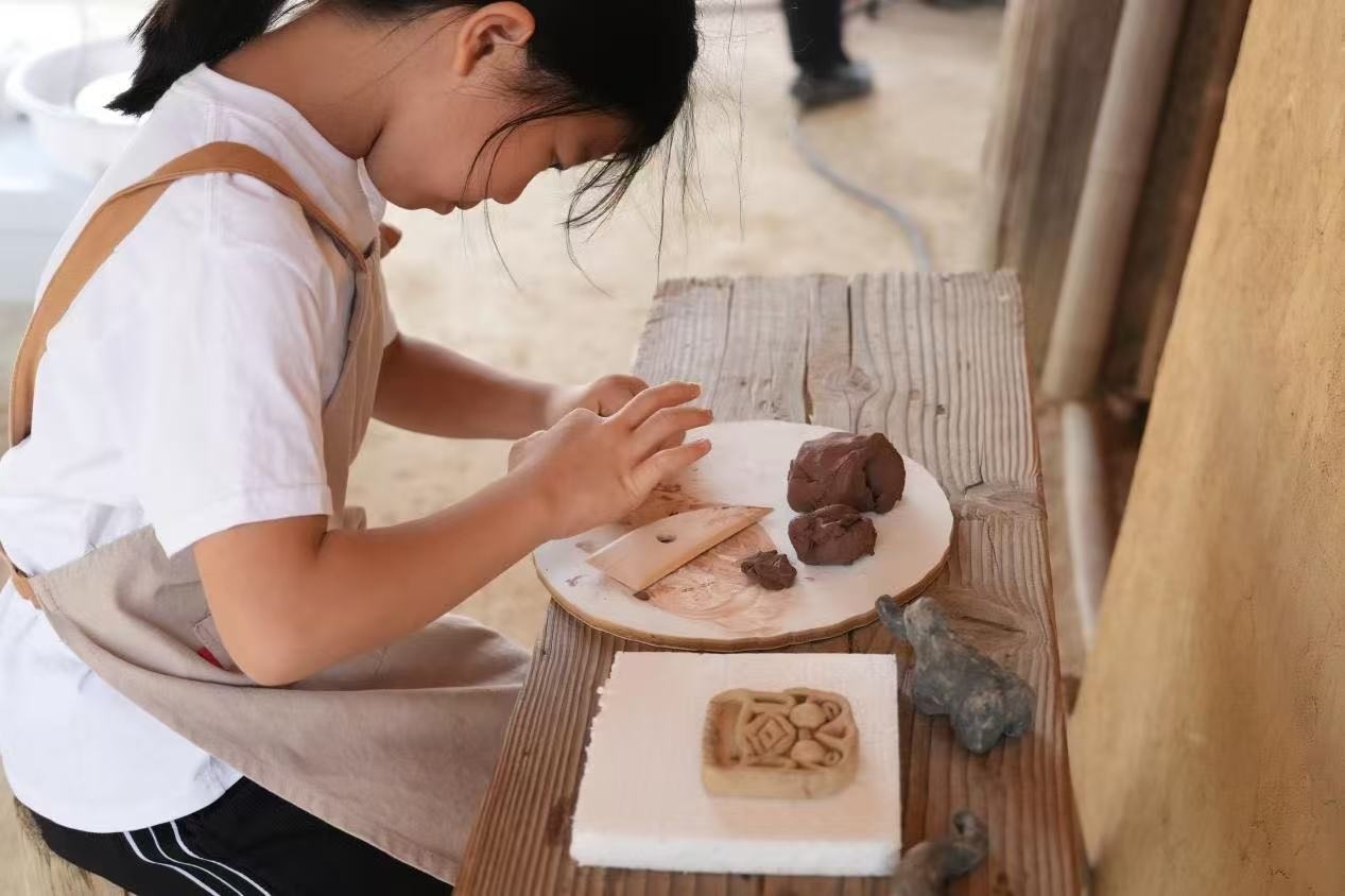 游客制作良渚特色陶藝品。良渚博物院供圖