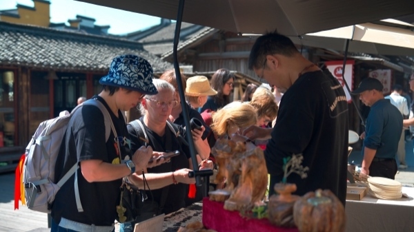 “五一”期間，游客正在烏鎮(zhèn)“水鄉(xiāng)碼頭”挑選購買文創(chuàng)產(chǎn)品。受訪者供圖