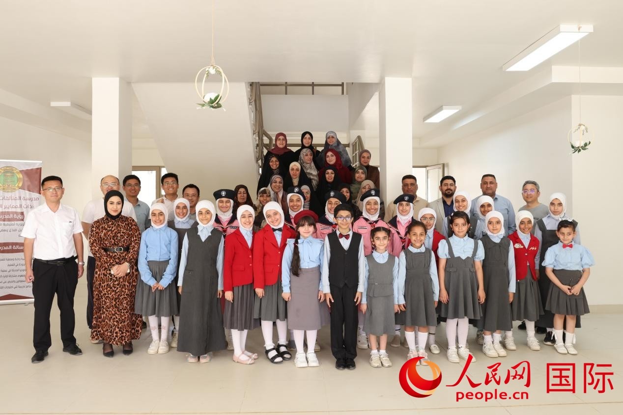中國電建員工與阿爾穆塔?阿里卡特國際學(xué)校的師生及政府官員等合影。人民網(wǎng)記者 薛丹攝