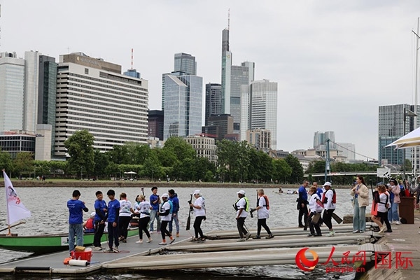 來自美國的快樂龍舟隊(duì)選手們正在登船準(zhǔn)備參賽。人民網(wǎng)記者 劉仲華攝