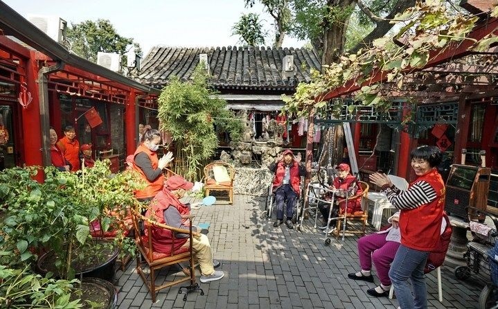 2024年10月12日，鐘樓灣胡同的老年人在社區(qū)內(nèi)的四合院養(yǎng)老驛站休閑。2017年起，北京市先后開展了兩輪背街小巷環(huán)境整治提升行動，完整保留了中軸線生活建筑群的歷史信息，并根據(jù)居民的生活和居住方式進行適配化的更新和改造，極大地改善了生活環(huán)境。2023年鐘樓灣胡同被評為“北京最美街巷”。