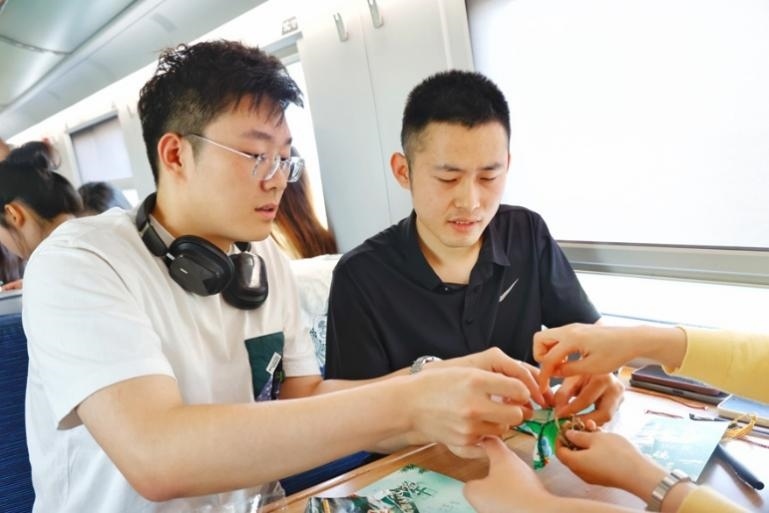 G232次旅客親手制作端午荷包和五彩繩。王磊攝