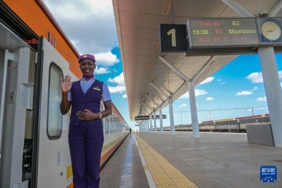 5月31日，在蒙內(nèi)鐵路內(nèi)羅畢站，一名乘務員在即將開往蒙巴薩的E2次列車旁等候乘客。新華社記者 楊光 攝