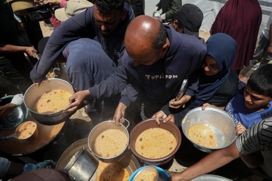 5月28日，人們在加沙城西部的沙提難民營領(lǐng)取救助食物。新華社發(fā)（里澤克·阿卜杜勒賈瓦德攝）